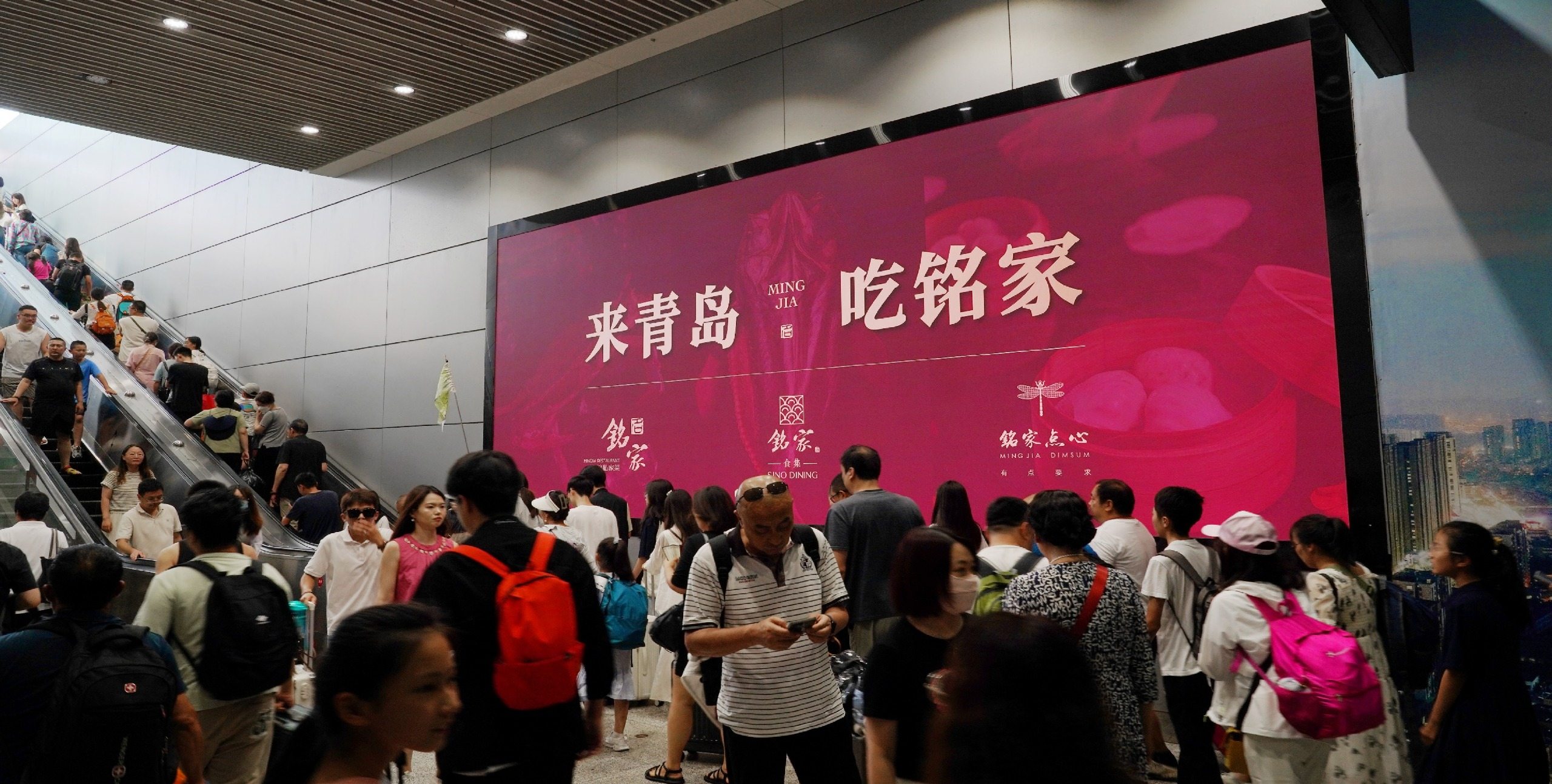 青岛北站西广场出入口扶梯旁LED大屏实景图-铭家餐饮